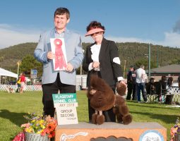 Two people stand with a poodle at a dog show; one holds a red ribbon for Group Second, Flagstaff Kennel Club, July 2018.